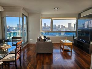 a living room with a couch and a large window at Puerto Madero frente al Hotel Hilton Vista a la Ciudad in Buenos Aires