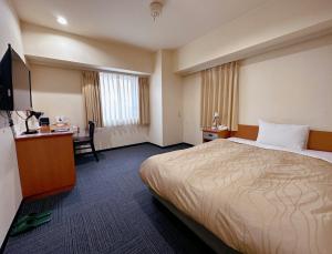 Cette chambre comprend un lit et un bureau. dans l'établissement Nissay Hotel Fukuoka - Vacation STAY 80167v, à Fukuoka