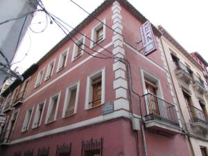 Edificio rojo con ventanas y balcón en Residencia Ziri en Granada