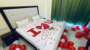 a bed covered in red decorations with balloons on it at Royal Neptunian Beach Cottages Arambol Goa in Arambol +3 photos