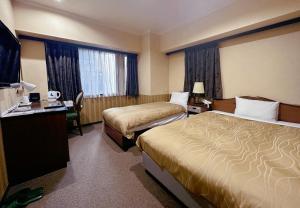 福岡市にあるNissay Hotel Fukuoka - Vacation STAY 80182vのベッド2台とデスクが備わるホテルルームです。
