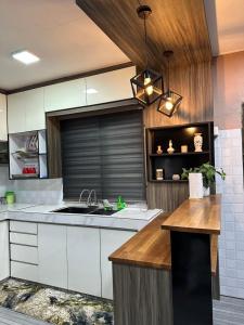 a kitchen with white cabinets and a sink at Te’bing Homestay in Paka