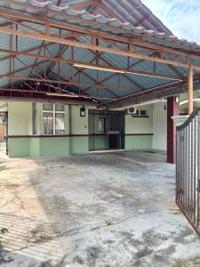 an empty parking lot with a metal roof on a building at Te’bing Homestay in Paka