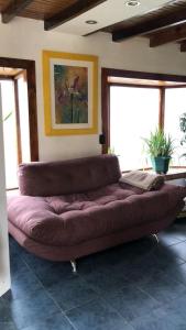 a large brown couch in a room with windows at Dream Landscape in Ushuaia