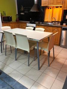 - une table et des chaises blanches dans la cuisine dans l'établissement Dream Landscape, à Ushuaia