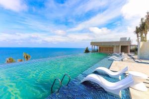 a swimming pool with a view of the ocean at Apec Mandala Mũi Né Condotel in Mui Ne
