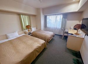 a hotel room with two beds and a television at Nissay Hotel Fukuoka - Vacation STAY 80184v in Fukuoka