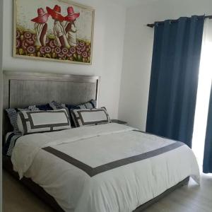 ein Schlafzimmer mit einem Bett und einem Wandgemälde in der Unterkunft Playa Coral Condo in Paradise F22 in Punta Cana