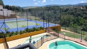 クリティにあるhermosa casa en curitíのテニスコートとテニスコート付きのプールを提供しています。