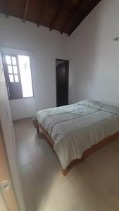 1 dormitorio con 1 cama en una habitación blanca en hermosa casa en curití en Curití