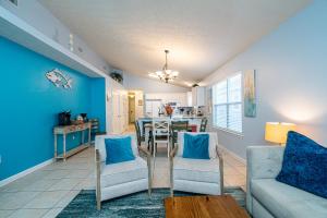 sala de estar con paredes azules, mesa y sillas en PALM COVE VACATION HOME- One level, Community pool, Pet Friendly, en Panama City Beach