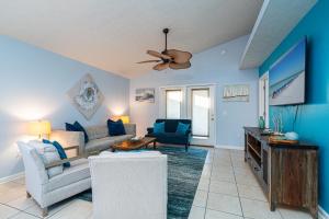 a living room with blue walls and a ceiling fan at PALM COVE VACATION HOME- One level, Community pool, Pet Friendly in Panama City Beach