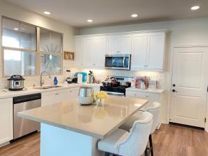 a kitchen with white cabinets and a kitchen island with chairs at OC lrvine eastwood family Lux 4beds &3 bath villa in Irvine