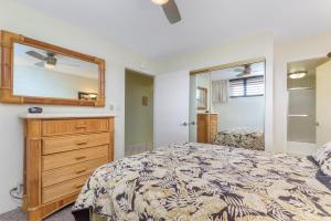 a bedroom with a bed and a dresser and a mirror at Kihei Surfside 613 - MCH in Kihei +39 photos