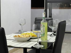 einen Tisch mit einer Flasche Wein und Weingläsern in der Unterkunft El mirador paisa in Bello