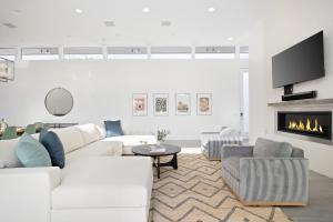 uma sala de estar com mobiliário branco e uma lareira em Polo Villa 10 by AvantStay Backyard Oasis w Putting Green 260-320 6 Bedrooms em La Quinta