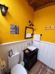 een badkamer met een wit toilet en een gele muur bij Mary's House in Puerto Iguazú