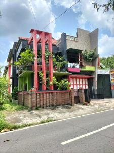 un bâtiment avec une grande structure rouge sur le côté de la rue dans l'établissement Mozza guest house, à Klaten