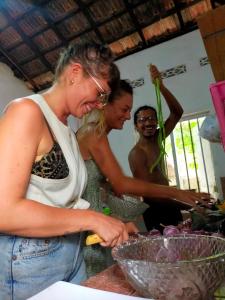 a group of people standing in a kitchen preparing food at Eastwind Surf Camp in Arugam Bay