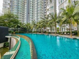 una piscina con palmeras y edificios en 1Medini Theme Suite by Nest Home【LEGOLAND】 en Nusajaya