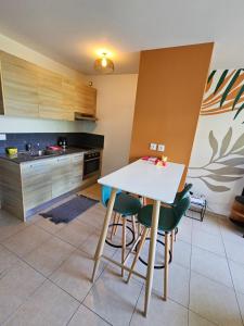 a kitchen with a white table and some chairs at Studio Papeete City Center in Papeete