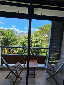 a balcony with two chairs and a view of the ocean at Studio Papeete City Center in Papeete