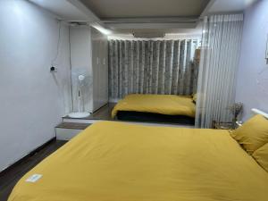two beds in a room with yellow sheets at Duplex WARM HANOI, 2 bedrooms, Old Quarter, 3mins to Hoan Kiem Lake in Hanoi