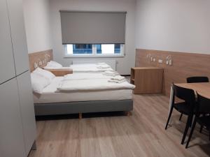 sypialnia z 2 łóżkami i stołem z krzesłami w obiekcie Centrum Szkoleniowo - Noclegowe HHM HEGELMANN 