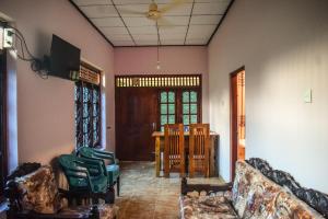 a living room with chairs and a table and a ceiling at PENGIRIWATTA REST INN in Kamburugamuwa