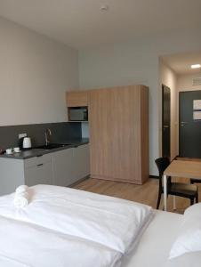 sypialnia z białym łóżkiem i kuchnią w obiekcie Centrum Szkoleniowo - Noclegowe HHM HEGELMANN 