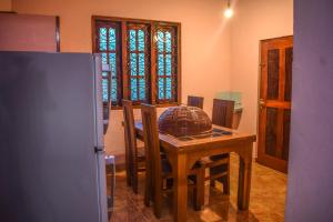 a kitchen with a table and chairs and a refrigerator at PENGIRIWATTA REST INN in Kamburugamuwa