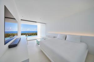 Dormitorio blanco con cama y ventana grande en EMIL NAKIJIN en Shoshi