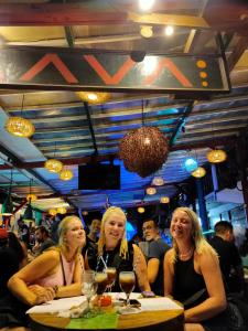 trzy kobiety siedzące przy stole w barze w obiekcie Gili Beach Bum Hotel w Gili Trawangan