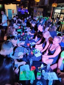 un grupo de personas sentadas en mesas en una fiesta en Gili Beach Bum Hotel en Gili Trawangan