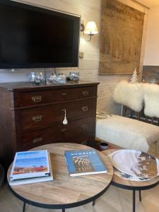 een woonkamer met een tafel met twee boeken en een tv bij Appartement de charme Avoriaz in Avoriaz