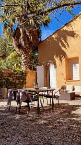 a picnic table and chairs in front of a building at Le mas du bosc in Mauguio