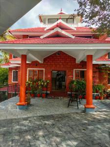 uma casa de tijolos vermelhos com pilares laranja à frente em Kannur Ayurvedic Centre em Kalpatta