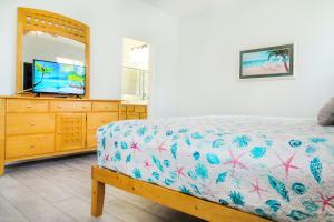 1 dormitorio con 1 cama y vestidor con TV en Modern 5 Bed4.5 Bath PoolSpa Villa in Watersong, en Loughman