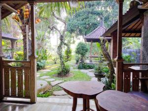 a garden with two tables and a gazebo at Tangkas wooden house in Tampaksiring