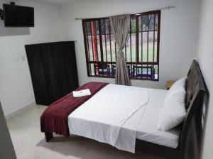 sypialnia z łóżkiem i oknem w obiekcie Hospedaje villa luz w mieście Pitalito
