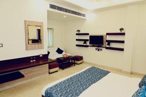 Habitación de hotel con cama y espejo en Hotel Varuna Inn, en Varanasi