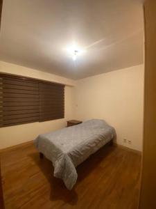 Schlafzimmer mit einem Bett und Holzboden in der Unterkunft Apartamento en la Av. Arce in La Paz