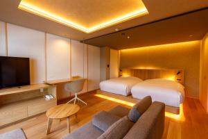 a hotel room with two beds and a television at Sake Hotel Tamakiya in Tokamachi