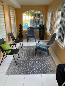a porch with chairs and a rug on a patio at Travelers Oasis in Portmore