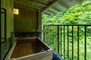 a hot tub sitting on a screened porch with a porch at Sake Hotel Tamakiya in Tokamachi