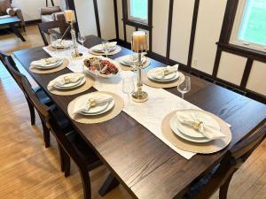 a wooden table with plates of food and wine glasses at Spacious Home Lake Minnetonka Downtown Excelsior in Excelsior