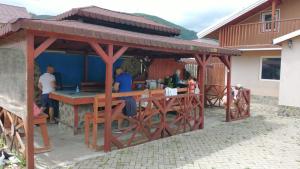 a wooden pavilion with people sitting at a table at CABANA ADAM SI EVA in Gura Râului