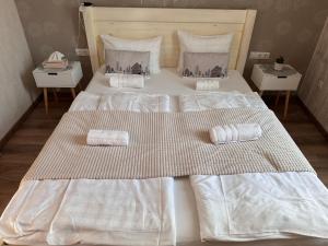 1 cama blanca grande con 2 toallas en Safit-Mandala en Mosonmagyaróvár
