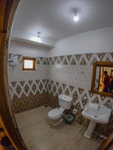 La salle de bains est pourvue d'un lavabo, de toilettes et d'un miroir. dans l'établissement Mountain Range Cottage, à Ella