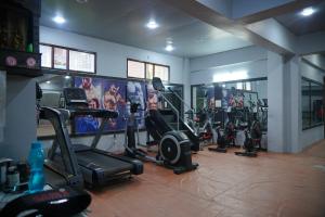 a gym with several tread machines in a room at JB Hotel and Resort in Lohaghāt